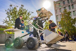 The Aurora Robotics Team alongside the Excahauler robot at UAF's 2024 Party in the Park.